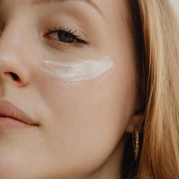 Pretty woman applying eye cream